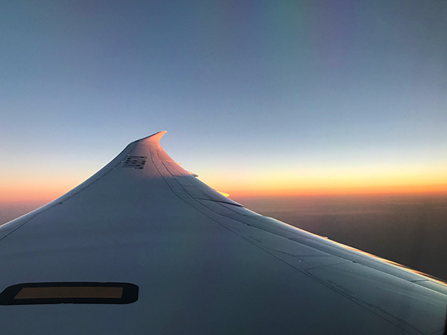 飛行機の翼と夕日と雲